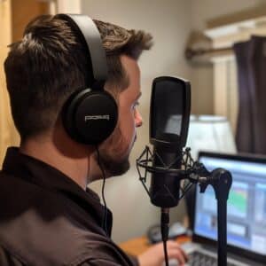 A man in a professional setting records a B2B podcast, using high-quality audio equipment to ensure clear and engaging content delivery, showcasing the technical setup required for producing professional business podcasts.