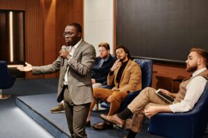 Image of man speaking on small stage, used on blog about podcasting for financial services