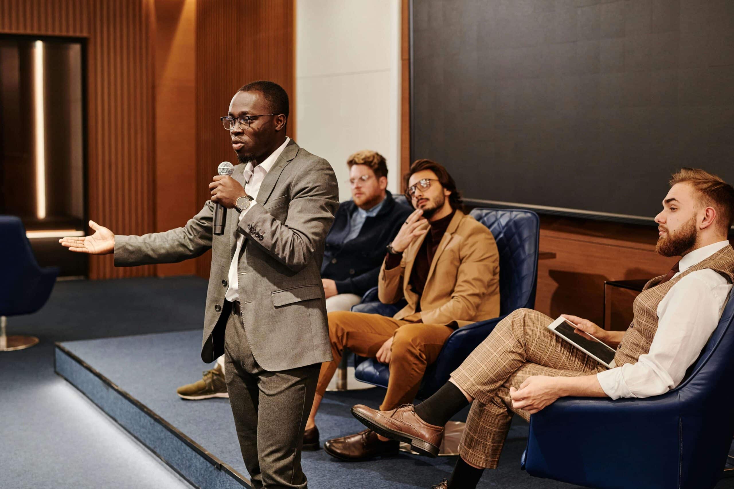 Image of man speaking on small stage, used on blog about podcasting for financial services